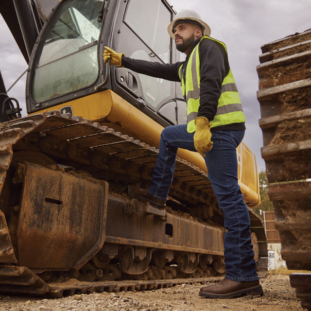 A construction worker wearing Justin Work boots on a job site